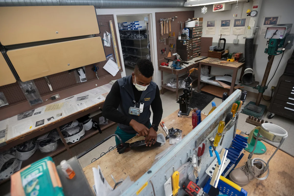 UC Davis Health prosthetist orthotist inspects prosthetic hand in lab.