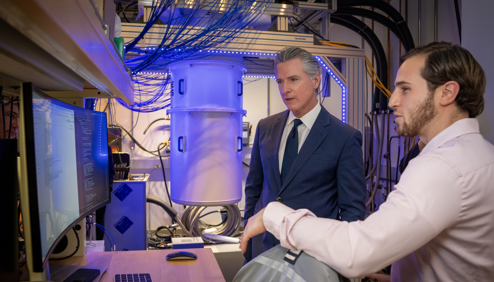 Newsom talking with quantum scientist Akel Hashim in the Campbell Hall lab of Irfan Siddiqi. 
