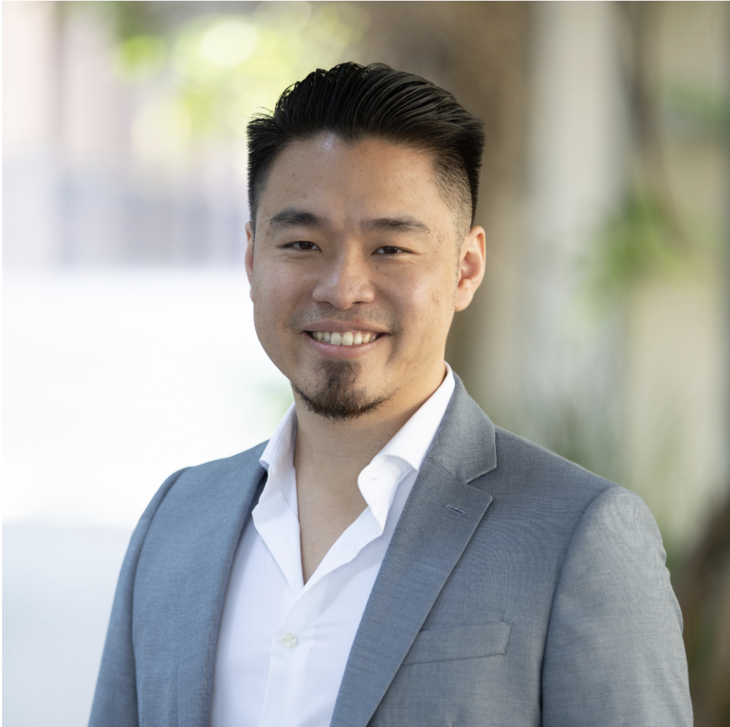 Portrait of Peter Chang wearing a white collared shirt and grey sports coat.