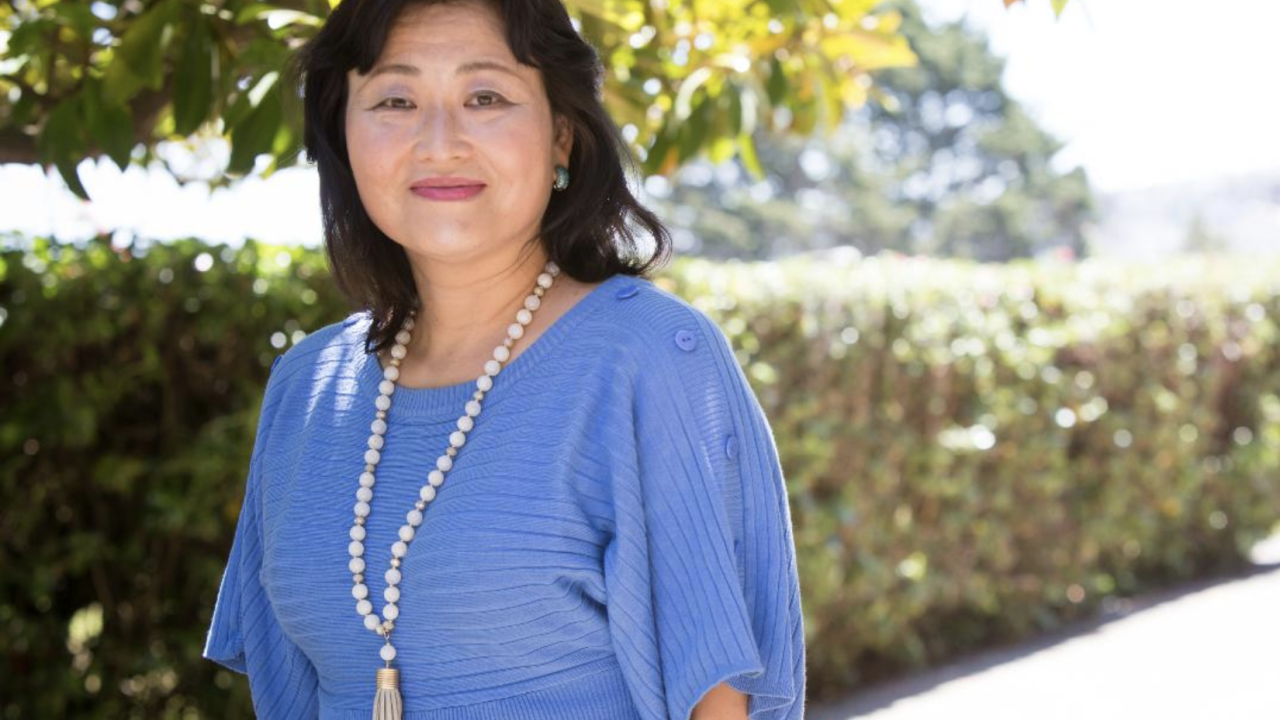 portrait of Yoshimi Fukuoka, RN, PhD, FAAN outside wearing a light blue dress and necklace.