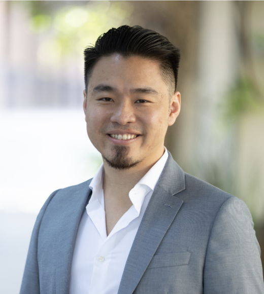 Portrait of Peter Chang wearing a white collared shirt and grey sports coat.